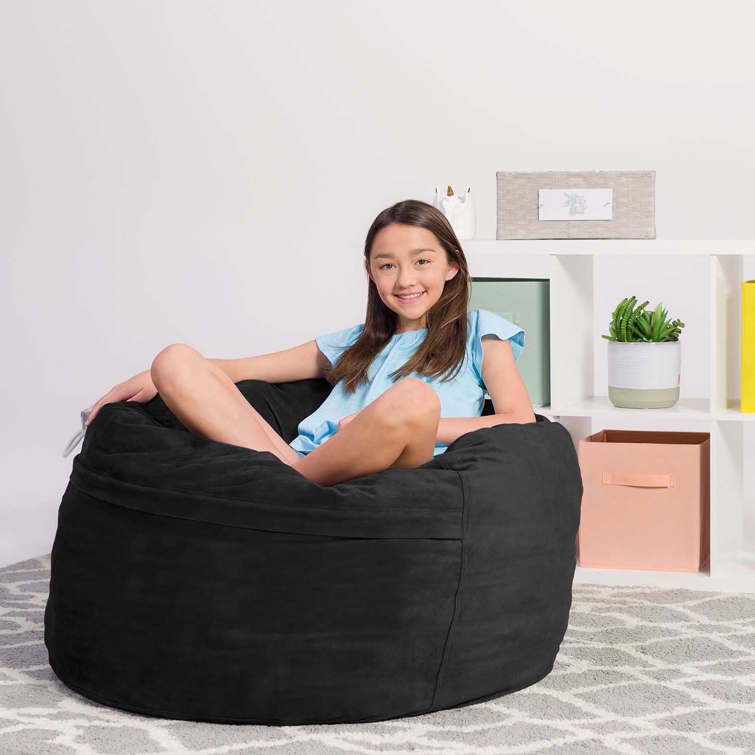 Girl lounging on black bean bag chair