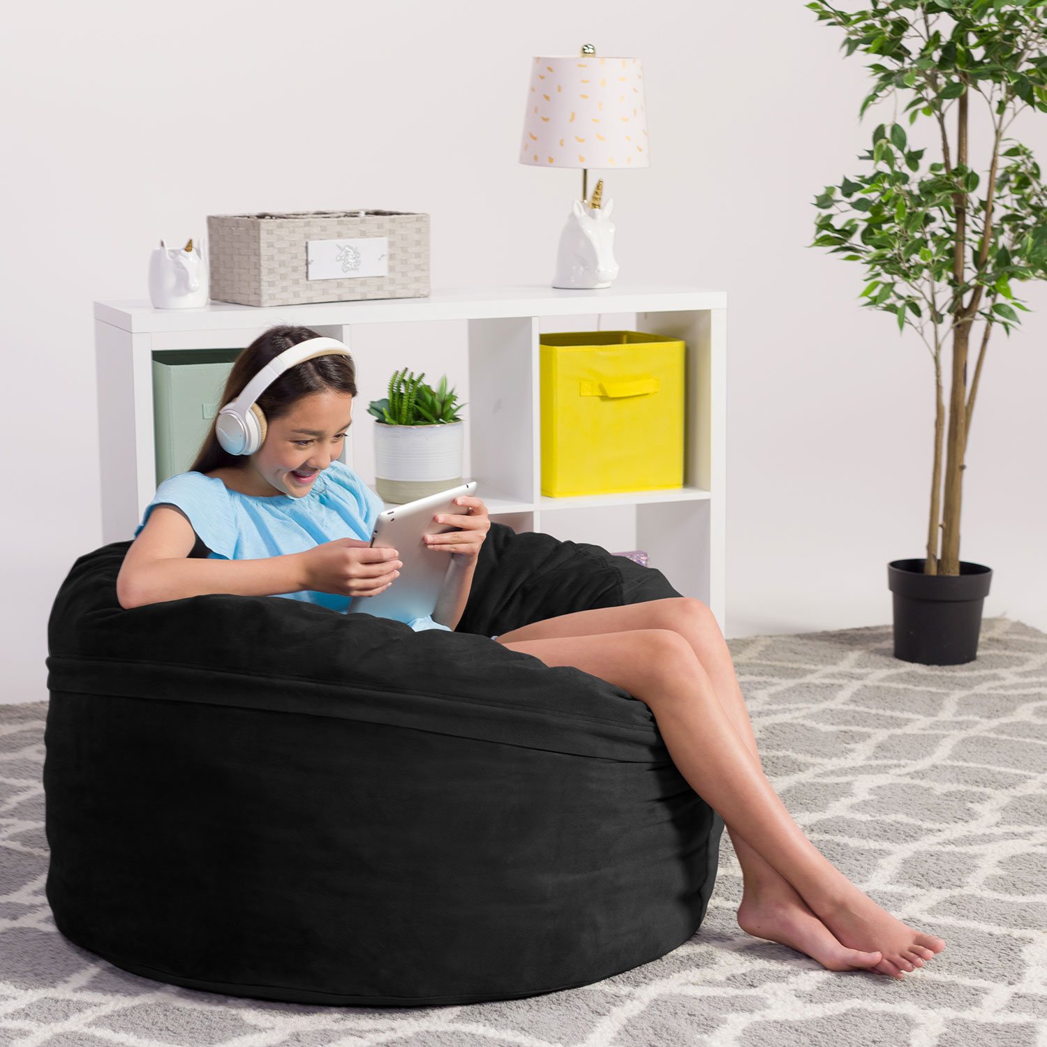Girl relaxing on black bean bag chair with tablet