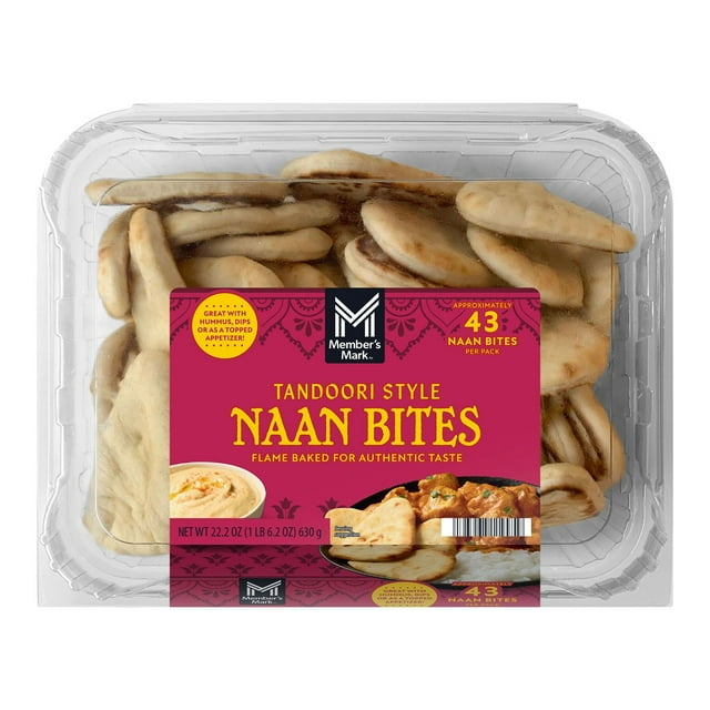 member's mark tandoori style naan bites, 22.2 oz. Front-facing clear clamshell of bite-sized oval flatbreads with light char marks and airy texture; magenta label notes flame-baked at 650°F and approx. 43 naan bites per pack and shows a dip serving suggestion. Packaged bakery flatbreads on white background, ideal for serving with dips, spreads or as an appetizer for gatherings.